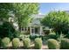 A backyard featuring a charming screened-in porch, lush landscaping, and manicured bushes at 418 Byrams Ford Dr, Cary, NC 27513