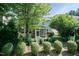 A backyard showcasing a cozy screened-in porch surrounded by lush greenery and trimmed bushes at 418 Byrams Ford Dr, Cary, NC 27513