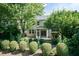 Well-maintained backyard featuring mature trees and shrubbery framing the home and screened-in porch at 418 Byrams Ford Dr, Cary, NC 27513
