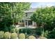 A backyard with a screened-in porch and stone patio, surrounded by trees and manicured shrubbery at 418 Byrams Ford Dr, Cary, NC 27513