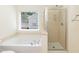 Bathroom featuring a bathtub and a separate glass shower with a large window at 418 Byrams Ford Dr, Cary, NC 27513