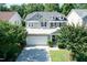 Two-story home with blue shutters, stone accents, a lush front lawn, and a two car garage at 418 Byrams Ford Dr, Cary, NC 27513