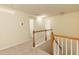 Upstairs hallway with carpet flooring and wood railing leading to bedrooms and bathrooms at 418 Byrams Ford Dr, Cary, NC 27513