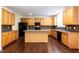 Kitchen features wood cabinets, tile backsplash, stainless steel appliances, and center island at 418 Byrams Ford Dr, Cary, NC 27513