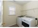 Bright laundry room with a window, overhead wire shelf, and modern washer and dryer units at 418 Byrams Ford Dr, Cary, NC 27513