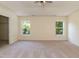 Spacious main bedroom featuring carpeted floors, a ceiling fan, and bright windows at 418 Byrams Ford Dr, Cary, NC 27513