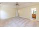 Main bedroom with carpet, tray ceiling, ceiling fan, and a bathroom with a wooden vanity at 418 Byrams Ford Dr, Cary, NC 27513