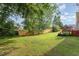 Spacious backyard with green grass, mature trees, and a wooden fence ensures privacy at 432 Barn View Ct, Fuquay Varina, NC 27526