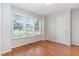 Sunlit bedroom with hardwood floors, a large window, and a neutral color scheme at 432 Barn View Ct, Fuquay Varina, NC 27526