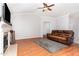 Cozy living room featuring a fireplace, hardwood floors, and a comfortable leather sofa at 432 Barn View Ct, Fuquay Varina, NC 27526