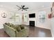 Bright living room featuring a comfortable green couch, fireplace, ceiling fan, and ample natural light at 4505 Wingate Song Ct, Knightdale, NC 27545