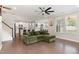Open-concept living room features hardwood floors, a comfortable green couch, and views into the kitchen at 4505 Wingate Song Ct, Knightdale, NC 27545