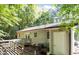 Backyard featuring a wood deck with steps, offering a tranquil setting surrounded by lush greenery and shade at 472 Shawnee Dr, Louisburg, NC 27549