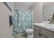 Bathroom with a toilet, sink, vanity, and shower with a tropical-themed curtain at 472 Shawnee Dr, Louisburg, NC 27549