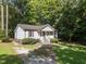 Charming home with a welcoming porch and ample green space surrounded by mature trees, creating a peaceful setting at 472 Shawnee Dr, Louisburg, NC 27549