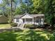 Charming single-story home with a cozy front porch and lush green lawn, surrounded by mature trees at 472 Shawnee Dr, Louisburg, NC 27549
