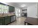 Kitchenette with green cabinets, stainless steel appliances, and a utility closet with washer and dryer at 472 Shawnee Dr, Louisburg, NC 27549
