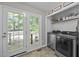 Laundry room featuring modern washer and dryer units, shelves, and a door to the outside at 472 Shawnee Dr, Louisburg, NC 27549