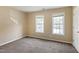 Bedroom with neutral walls and carpeting featuring lots of sunlight through two windows at 4802 Parkville Dr, Raleigh, NC 27604
