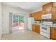 Kitchen with modern appliances, wooden cabinets, tile floors, and sliding door to deck at 4802 Parkville Dr, Raleigh, NC 27604