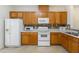 Kitchen featuring wooden cabinets, white appliances, tile flooring, and great countertop space at 4802 Parkville Dr, Raleigh, NC 27604
