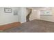 Open-concept living room featuring carpet, stairs, white walls, and hardwood flooring at 4802 Parkville Dr, Raleigh, NC 27604