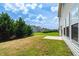 A multi home back yard view features large evergreen trees and newly planted grass at 517 Eagles Way, Mebane, NC 27302
