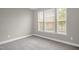 A neutral bedroom features plush carpet, fresh paint and triple windows for natural light at 517 Eagles Way, Mebane, NC 27302