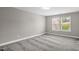 A neutral bedroom features plush carpet, fresh paint and double windows for natural light at 517 Eagles Way, Mebane, NC 27302