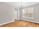 A dining room with hardwood floors, neutral wall color, ample natural light, and chandelier at 517 Eagles Way, Mebane, NC 27302