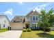 Two-story home with a two-car garage, landscaped yard, and a combination of siding and stone accents at 517 Eagles Way, Mebane, NC 27302