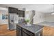 Kitchen island with granite countertop adjacent to carpeted living room and stainless steel refrigerator at 517 Eagles Way, Mebane, NC 27302
