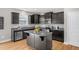 Modern kitchen features dark cabinets, stainless steel appliances, granite counters, and an island at 517 Eagles Way, Mebane, NC 27302