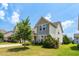 A two-story home showcasing a well-kept lawn, with a combination of siding and stone accents at 517 Eagles Way, Mebane, NC 27302