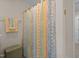 Bathroom corner with a vibrant patterned shower curtain and decorative towel at 5216 Marcella Ct, Durham, NC 27707
