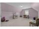 Spacious bedroom with angled ceilings, plush carpet, and a charming accent chair at 5216 Marcella Ct, Durham, NC 27707