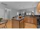 Open-concept kitchen with wood cabinets, an island, and views into the living area at 5216 Marcella Ct, Durham, NC 27707