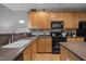 Charming kitchen featuring wood cabinets, updated countertops, and modern black appliances at 5216 Marcella Ct, Durham, NC 27707