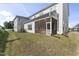 View of the home's backyard, featuring a screened-in porch and lush green lawn at 533 Kings Lake Way, Durham, NC 27703