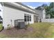 View of the home's backyard, featuring an AC unit, landscaping, and screened-in porch at 533 Kings Lake Way, Durham, NC 27703