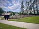 Another view of the neighborhood dog park with mature trees and benches at 533 Kings Lake Way, Durham, NC 27703