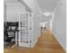 Bright hallway with hardwood floors, leading to a living area and featuring an office space with glass door at 533 Kings Lake Way, Durham, NC 27703