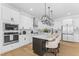 Bright kitchen with stainless steel appliances, white cabinets, and an island with seating at 533 Kings Lake Way, Durham, NC 27703
