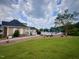 Beautiful pool and pool house overlook lush lawn on a sunny day with cloudy blue skies at 533 Kings Lake Way, Durham, NC 27703