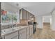 An eat-in kitchen boasts a double sink, wood-look flooring, and mosaic tile backsplash at 64 Doughty Ln # E, Middlesex, NC 27557