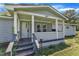 Close up of covered front porch with painted wood deck and posts and a storm door at 64 Doughty Ln # E, Middlesex, NC 27557