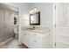 Bright bathroom featuring a granite countertop vanity, a framed mirror, and a glass shower at 6609 Electra Dr, Raleigh, NC 27607