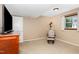 Simple bedroom features a window, chair, dresser, and neutral carpeting at 6609 Electra Dr, Raleigh, NC 27607