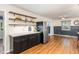 Eat-in kitchen has floating shelves, stainless refrigerator, and black lower cabinets at 6609 Electra Dr, Raleigh, NC 27607