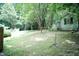 Backyard with lush greenery, mature trees, and well-maintained grass, offering a serene outdoor space at 7216 Rabbit Run, Wake Forest, NC 27587